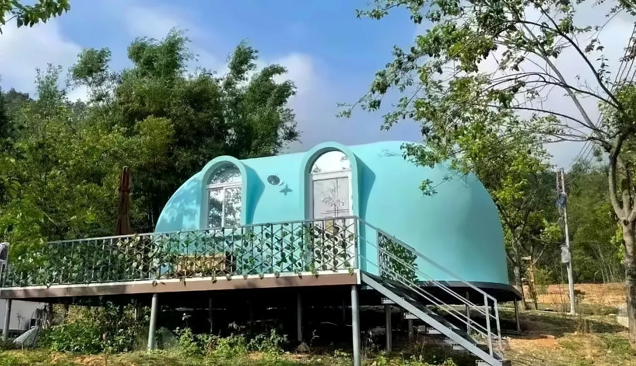 EPS dome cabin installed on a steel-frame platform over a graded slope — reference photograph