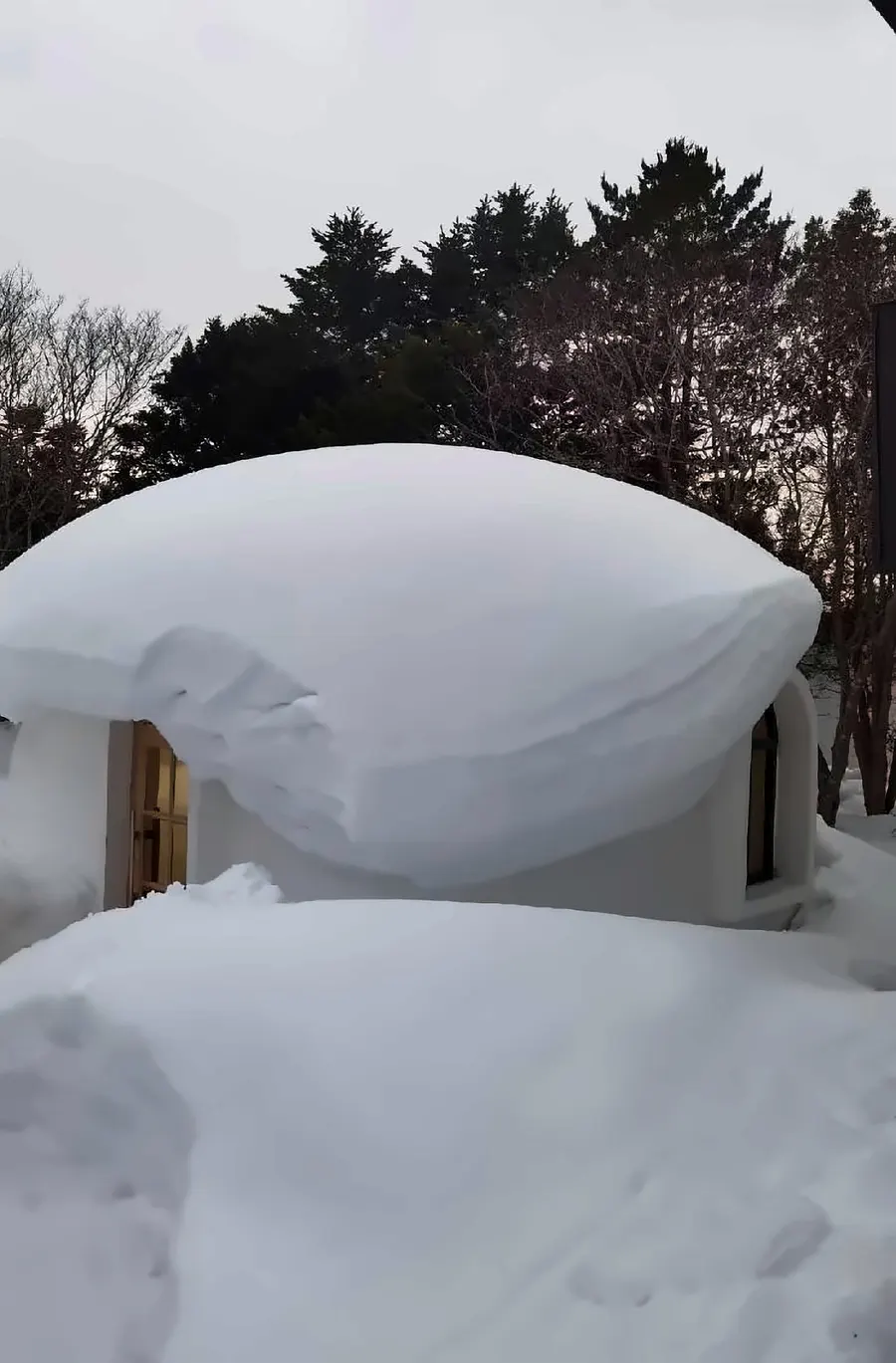 EPS dome cabin carrying a deep layer of standing snow on the arched roof, structure intact