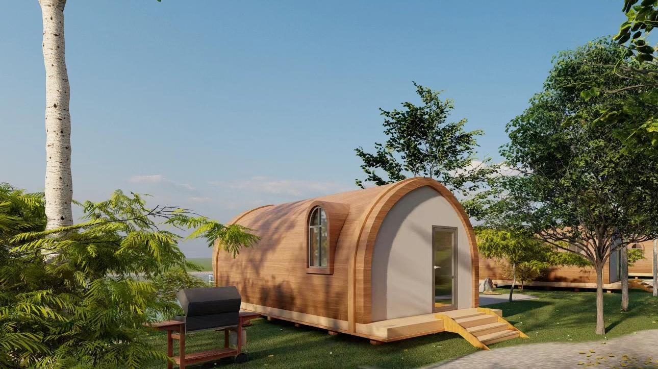 White modular dome cabin in a resort setting with landscape and deck