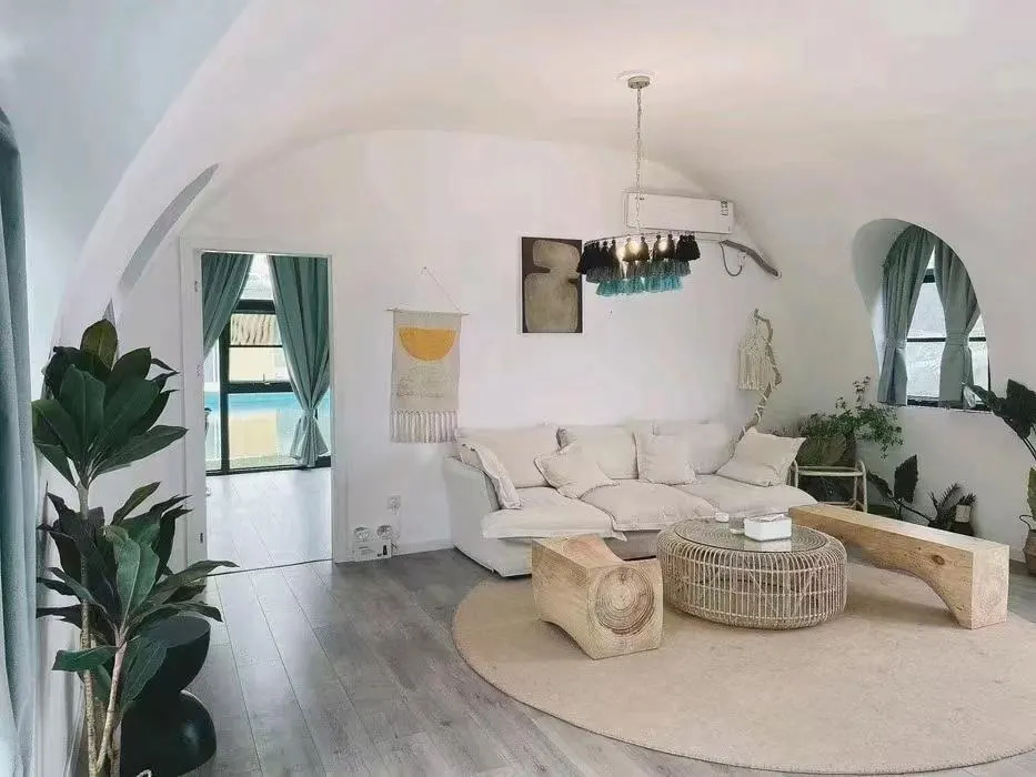 Living zone under the dome curve with sofa and rattan furniture