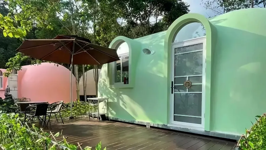 EPS dome cabins with deck terrace and parasol at a wooded glamping site