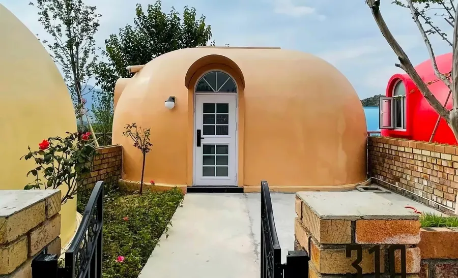 Front entry of an EPS dome with arched door surround and render finish