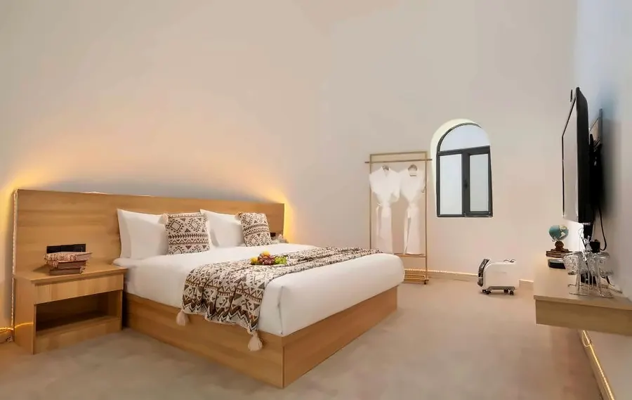 Warm wood king bedroom with arch window and bathrobe rack